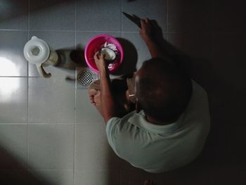 Midsection of man holding camera at home