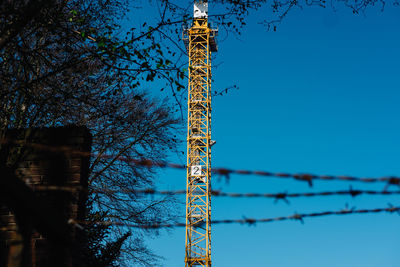 Low angle view of crane against sky