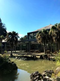 Building by lake against clear sky