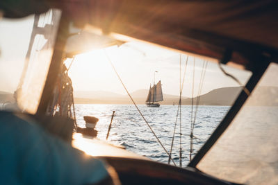 A schooner off the maine coast viewed through a boat's open window