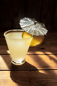 Summer alcoholic yellow drink in transparent shaped glass with sugar on the rim, photo for  bar menu