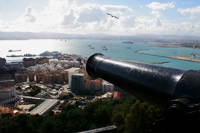 Aerial view of cityscape by sea against sky