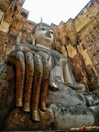 Low angle view of statue against historic building