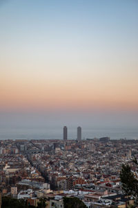 Aerial view of buildings in city against sky during sunset