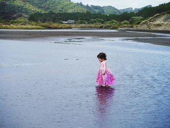 Full length of woman standing on pink lake