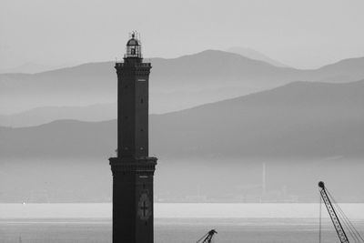 Lighthouse by sea against sky