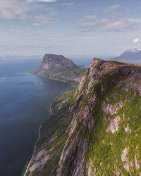 Scenic view of sea by mountains against sky