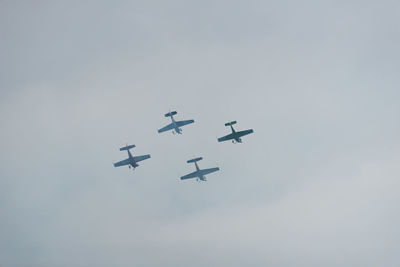 Low angle view of airplanes flying against sky during air show