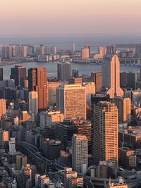 Modern buildings in city against sky during sunset