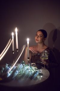 Portrait of smiling young woman holding illuminated candle