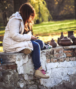 Side view of woman sitting outdoors