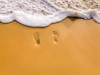 High angle view of footprints on sand at beach