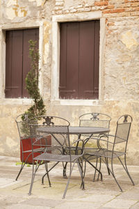 Chairs and tables on sidewalk against buildings in town