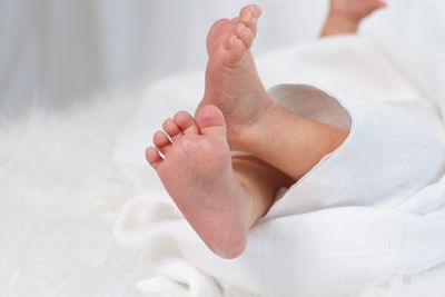 Low section of baby feet on bed