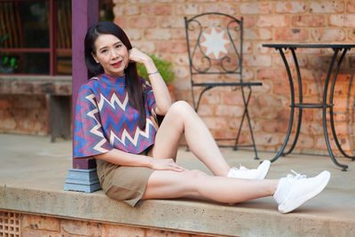 Portrait of a smiling young woman sitting outdoors