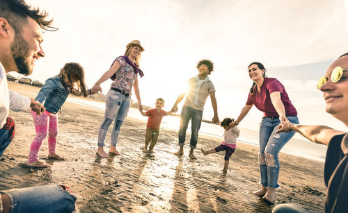 Group of people at beach against sky