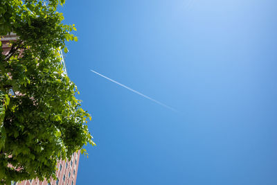 Low angle view of vapor trail against clear blue sky