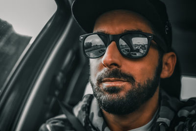 Portrait of man wearing sunglasses in car