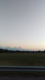 Scenic view of field against clear sky during sunset