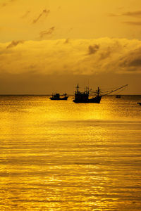 Silhouette boat in sea against sky during sunset