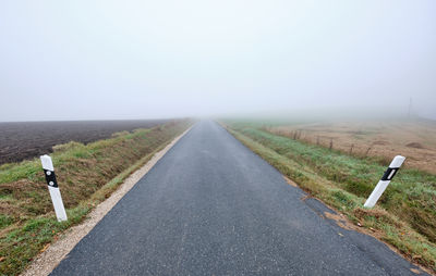 Road amidst field against sky