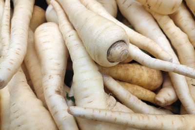 Close-up on a stack of sarsnips on a market stall.