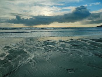 Scenic view of beach against sky during sunset