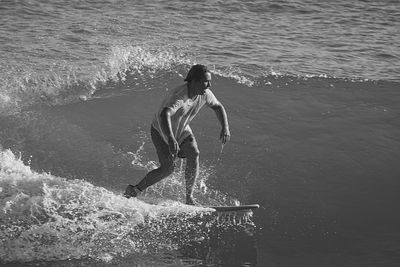 Full length of man splashing water in sea