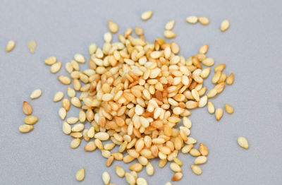 Close-up of sesame seeds on grey background.