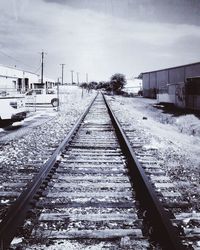 Railway tracks in winter against sky