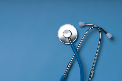 Low angle view of electric lamp against blue background