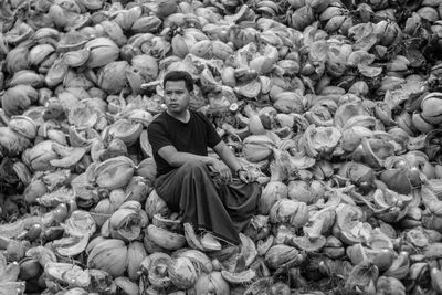 Portrait of young man sitting on stone wall