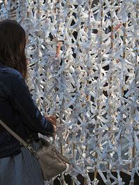 Woman tying fortune paper on fence