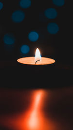 Close-up of lit candle in the dark