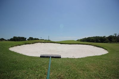 Sand trap at golf course against sky