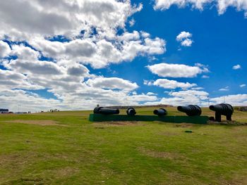 Hay bales on field against sky