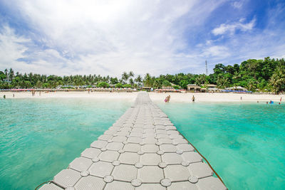 View of swimming pool in sea against cloudy sky