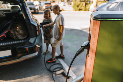 Electricity passing through plug connected in kiosk at vehicle charging station