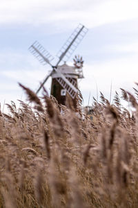 Traditional windmill on field against sky