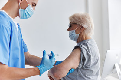 Side view of doctor examining patient at clinic