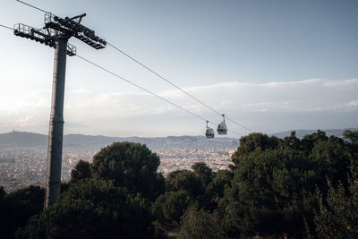 Overhead cable car over city against sky