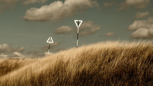 Wind turbines on field against sky