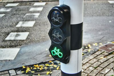 Close-up of illuminated bicycle traffic light on pole by street