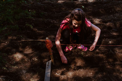 High angle view of girl planting on field