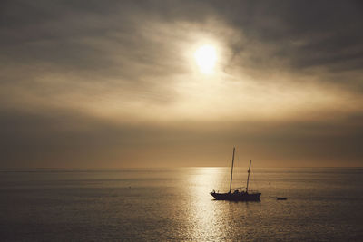 Silhouette ship sailing on sea against sky during sunset