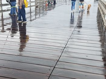Low section of people standing on wet floor