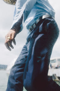 Midsection of man and woman standing against blurred background