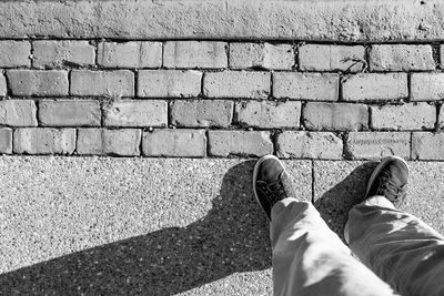 Low section of man standing on footpath