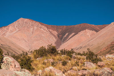 Scenic view of rocky mountains against clear blue sky