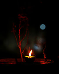 Close-up of lit diya burning at night